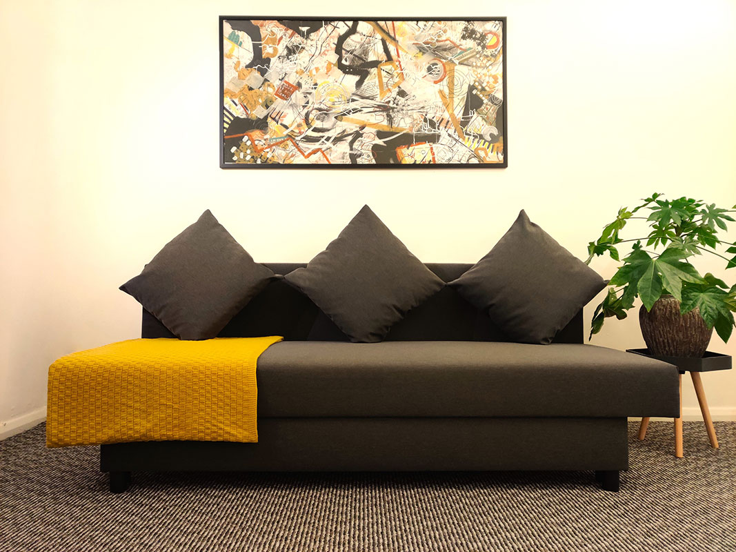 Abbey Wood Therapy, Therapy Room grey couch with yellow blanket.